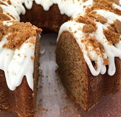 a bundt cake with white frosting and cinnamon crumbs sits on a pink plate