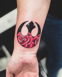 a person with a tattoo on their arm holding a rose in the shape of a star wars symbol