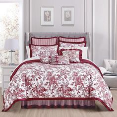 a bed with red and white comforters in a room