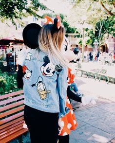 a woman in mickey mouse ears and denim jacket