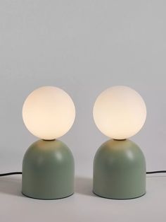 two lamps sitting on top of a table next to each other with one light turned off