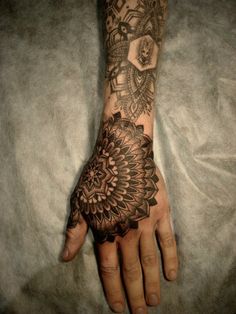 a person's hand with a tattoo on it and a flower in the middle