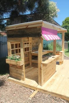 a wooden structure with plants growing out of the top and bottom shelves on each side