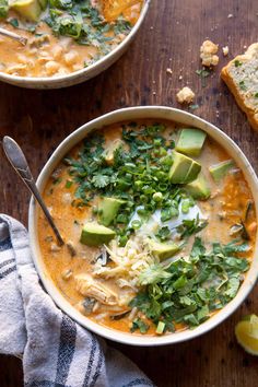 two bowls of chicken tortilla soup with avocado and cilantro