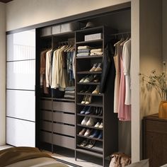 an organized closet with shoes and clothes hanging on the wall, along with a bed