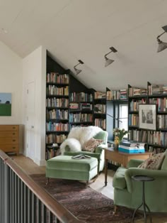 a living room filled with lots of furniture and bookshelves next to a window