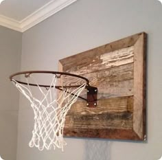 a basketball hoop mounted to the side of a wooden wall hanging on a gray wall