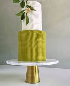 a green and white cake with leaves on top