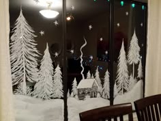 a window decorated with snow and christmas trees