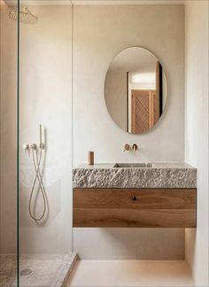 a bathroom with a sink, mirror and shower stall in it's center area