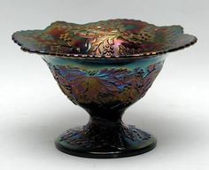 an ornate glass bowl is sitting on a white surface with no one in the photo