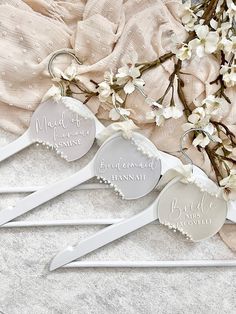 three bride and groom wedding hair combs with personalized names on them next to flowers