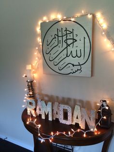 a decorated table with lights on it and a painting above the word rama in arabic