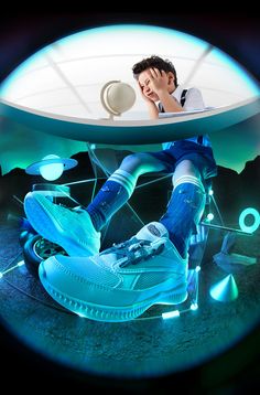 a man sitting on top of a blue shoe under a light up object with his feet in the air