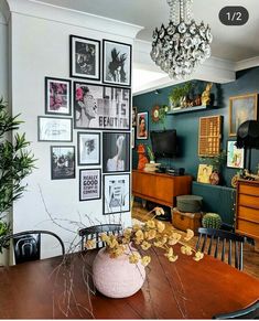 a dining room table with pictures on the wall