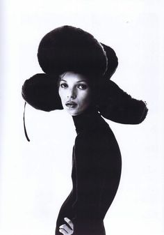 a woman in a black dress and large hat