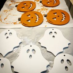 halloween decorations made out of white and orange paper with holes in the middle to make faces