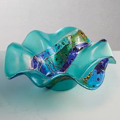 a blue glass bowl sitting on top of a table