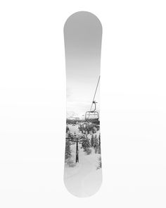 a snowboard with a ski lift on top of it and trees in the background