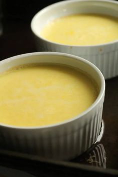 two white bowls filled with soup sitting on top of a table next to each other