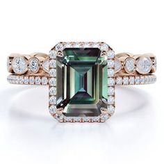 an emerald and diamond ring with diamonds around it