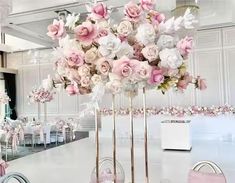 there are many flowers in tall vases on the tables at this wedding reception table