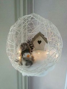 a bird is sitting in a glass ornament with lights on it's sides