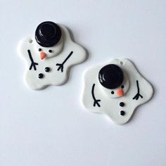 two white and black snowman buttons on a white surface