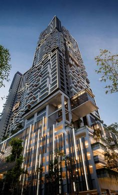 a tall building with many windows and balconies on the top floor is lit up at night