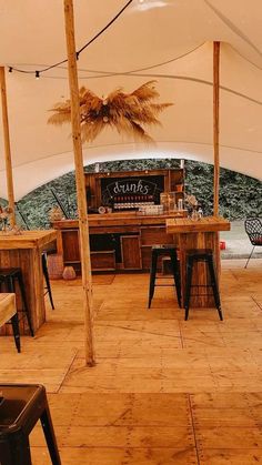 the inside of a tent with tables and stools under an awning that has palm trees on it