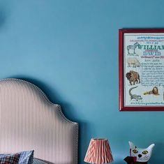 a bedroom with blue walls and a framed animal print on the wall next to a bed