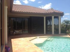 a pool in front of a house with sliding glass doors