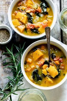 two bowls of vegetable soup on a wooden table