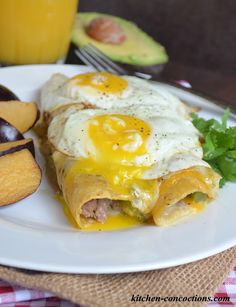 an egg burrito on a plate next to some fruit