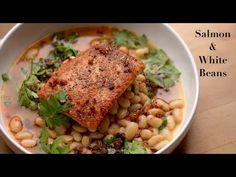 salmon and white bean soup in a bowl on a wooden table with the words salmon and white beans