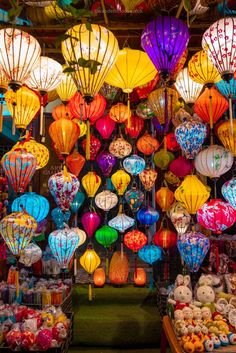 many colorful lanterns are hanging from the ceiling