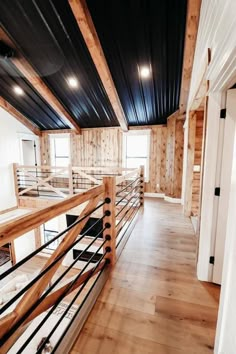 an empty room with wooden floors and black metal railings on the walls, along with wood flooring