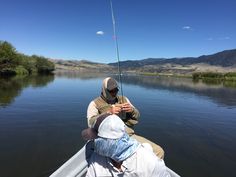 two people in a boat fishing on the water