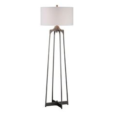 a floor lamp with a white shade on the top and an iron frame around it