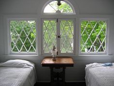 two twin beds in a room with windows