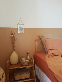 a bed room with a neatly made bed and a basket on the end table next to it