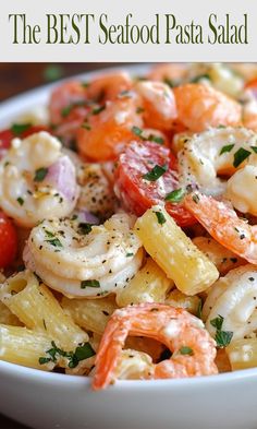 the best seafood pasta salad with shrimp, tomatoes and parsley in a white bowl