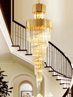 a chandelier hanging from the ceiling in a living room next to a staircase