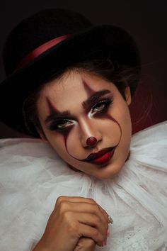 a woman with makeup on her face wearing a top hat