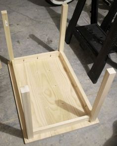 a wooden chair sitting on top of a floor next to a piece of plywood