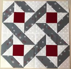 the block has red and grey squares on it with snowflakes in them, along with white polka dots