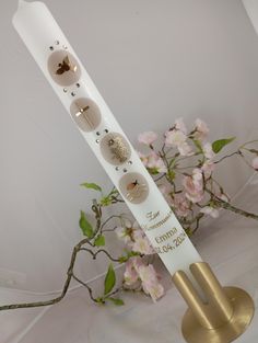 a white display stand with four different buttons on it and flowers in the back ground