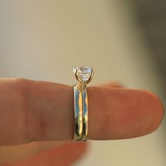 a close up of a person's hand with a ring on their finger that has a diamond in it