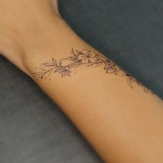 a woman's arm with a flower tattoo on the left side of her arm