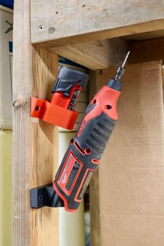 a cordless driller is attached to a wooden wall with two screwdrivers